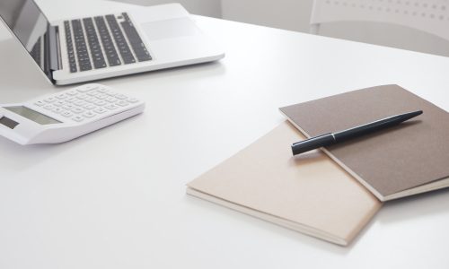 sporządzanie operatu szacunkowego na laptopie, na biurku dokumenty do wyceny nieruchomości